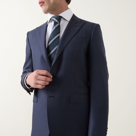 Model wearing Canali D8 Two-Piece Suit in navy wool, styled with a white shirt and green striped tie