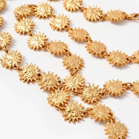 Mint Velvet gold-tone chain belt featuring linked sunburst coin discs, shown in close-up detail