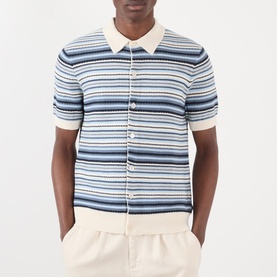 Model wearing NN07 Nolan Striped Polo Cardigan in Navy Multi, with polo collar, short sleeves and button front, styled with cream trousers.