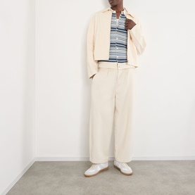 Model wearing NN07 Nolan Striped Polo Cardigan in Navy Multi, styled with cream wide-leg trousers, overshirt and white trainers.