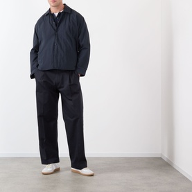 Model wearing NN07 Fenton Water Repellent Jacket in Deep Navy with matching dark trousers and white loafers.
