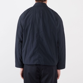 Model wearing NN07 Fenton Water Repellent Jacket in Deep Navy, showing rear view of lightweight textured polyamide casual jacket with shirt collar.