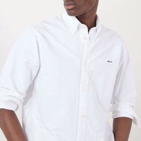Model wearing NN07 Colby Logo Shirt in white, showing button-down collar, long sleeves with rolled cuffs, and contrast chest logo.