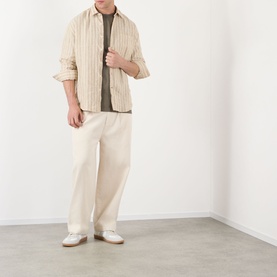 Model wearing NN07 Deon Linen Striped Shirt in Black Stripe, styled with cream wide-leg trousers and white loafers.
