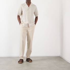 Model wearing NN07 Julio Linen Shirt in Oat with camp collar and short sleeves, styled with matching linen trousers and brown sandals