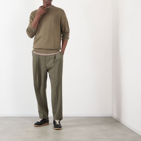 Model wearing NN07 Ted Linen Knitted Sweater in Capers, styled with matching tapered trousers and black low-top trainers.
