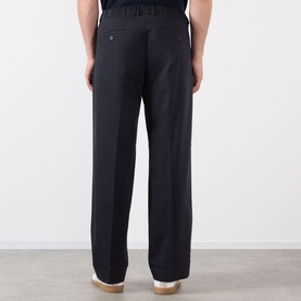 Model wearing NN07 Kay Relaxed Fit Pleated Trousers in navy blue, rear view showing four-pocket style and belt loops