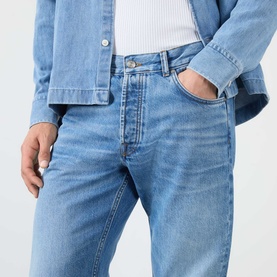 Model wearing NN07 light blue jeans in 100% cotton, styled with a denim shirt. Relaxed fit, five-pocket style.
