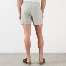 Model wearing NN07 Green Stripe shorts, back view, with elasticated waistband, styled with brown sandals