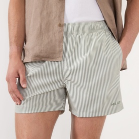 Model wearing NN07 Green Stripe shorts with elasticated waist, styled with a beige shirt.