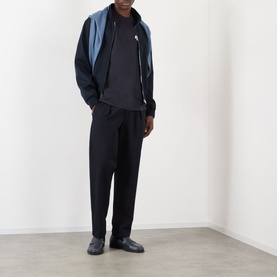 Model wearing NN07 Adam Rope Logo T-Shirt in Deep Navy, styled with a two-tone zip-up jacket and black tapered trousers.