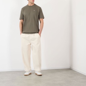 Model wearing NN07 T-Shirt in Capers, styled with cream wide-leg trousers and white trainers.