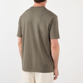 Model wearing NN07 T-shirt in Capers, rear view showing short sleeves and relaxed fit, styled with cream trousers.