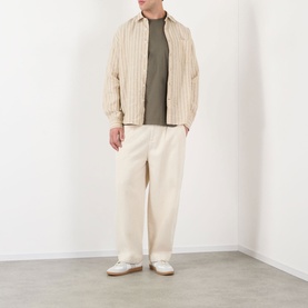 Model wearing NN07 Capers cotton T-shirt, styled with a striped cream overshirt and wide-leg ecru trousers.