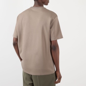 Model wearing NN07 T-Shirt in Clay Mirage, rear view, short sleeves, styled with olive green trousers.