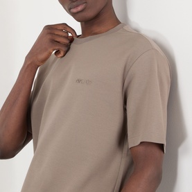 Model wearing NN07 T-Shirt in Clay Mirage, relaxed fit with crew neck and tonal chest logo, close-up detail shot