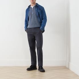 Model wearing Paige Eberton Tapered Leg Trousers in True Navy, styled with a denim jacket and grey polo shirt, black shoes.