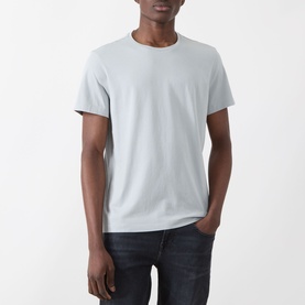 Model wearing Paige Sorden Solid T-Shirt in Bristol Blue, crew neck, short sleeves, paired with dark jeans.