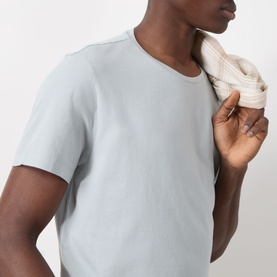 Model wearing Paige Sorden Solid T-Shirt in Bristol Blue, crew neck, short sleeves, styled with a striped knit thrown over shoulder.