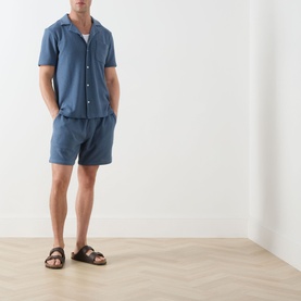 Model wearing Paige Oliver Patch Pocket Casual Shirt in Lakeside blue, styled with matching shorts and brown leather sandals.