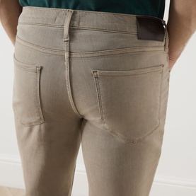 Model wearing Paige Federal Slim Straight Leg Jeans in Vintage Pale Beige, showing rear five-pocket detail with leather patch and contrast stitching.