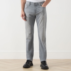 Model wearing Paige straight jeans in Wainwright grey, styled with black leather shoes. Five-pocket design with mid-rise waist.