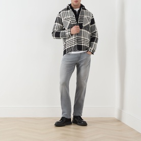Model wearing Paige Wainwright straight jeans in grey, styled with a black and white check overshirt and black loafers.