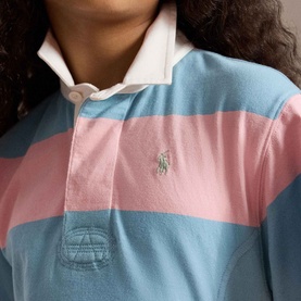 Model wearing Ralph Lauren Pony Logo Striped Rugby Dress in pink and blue stripes with embroidered Pony logo and rugby collar