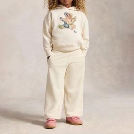 Model wearing Ralph Lauren Patchwork Polo Bear Logo Terry Hoodie in Guide Cream with matching wide-leg trousers and pink shoes.