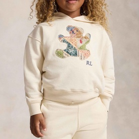 Model wearing Ralph Lauren Patchwork Polo Bear Terry Hoodie in Guide Cream with patchwork bear appliqu&eacute; and RL embroidery, styled with cream joggers.