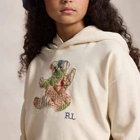 Model wearing Ralph Lauren Patchwork Polo Bear Logo Terry Hoodie in Guide Cream with embroidered patchwork bear and RL script detail