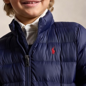 Model wearing Ralph Lauren The Colden Pony Logo Packable Quilted Jacket in Newport Navy with red embroidered Pony logo, styled with white shirt