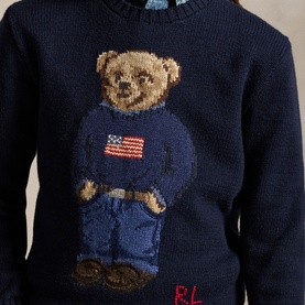 Ralph Lauren navy knit jumper with iconic Polo Bear graphic wearing American flag sweater and jeans, red RL logo detail