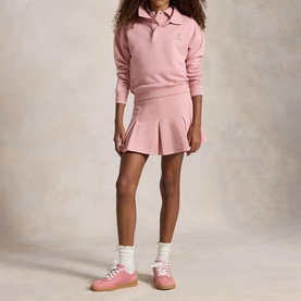 Model wearing Ralph Lauren Pony Logo Terry Polo Sweatshirt in Light Pink with matching pleated skirt and pink trainers.