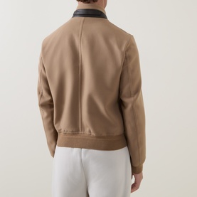 Model wearing Tom Ford Golden Brown wool-silk casual jacket, rear view, with dark leather collar and ribbed hem, styled with white trousers