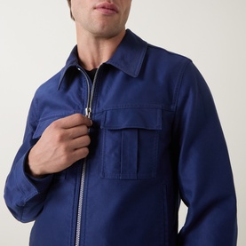 Model wearing Tom Ford navy cotton casual jacket with zip fastening and dual chest pockets, close-up detail view