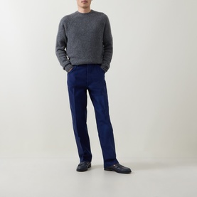 Model wearing Tom Ford Navy Blazer cotton casual trousers, styled with a grey marl crewneck sweater and black loafers.