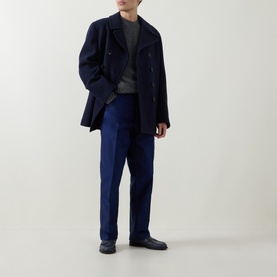Model wearing Tom Ford Navy Blazer casual cotton trousers, styled with a navy wool coat, grey knit and black leather shoes.