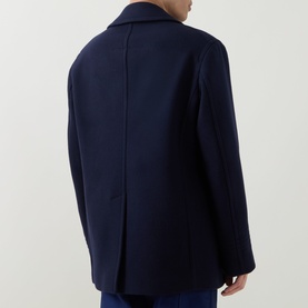Model wearing Tom Ford navy wool coat, rear view showing clean back seam and notched collar.