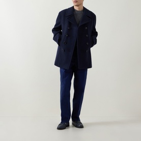 Model wearing Tom Ford navy wool peacoat, double-breasted with wide lapels, styled with navy trousers and black leather shoes.