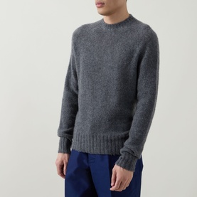 Model wearing Tom Ford Charcoal Cashmere Knit Sweater with crew neckline and ribbed trims, styled with blue trousers.
