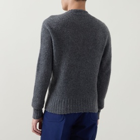 Model wearing Tom Ford Charcoal Cashmere Knit Sweater, crew neck with ribbed trims, shown from the back, styled with blue trousers.