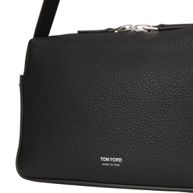 Tom Ford black leather crossbody bag, close-up showing pebbled texture, silver-tone zip and logo stamp detail