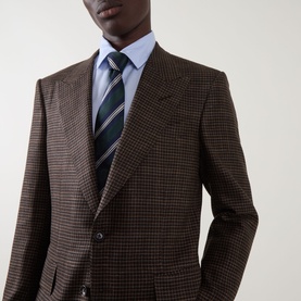 Model wearing Tom Ford black brown houndstooth wool blazer, styled with a light blue shirt and navy striped tie.