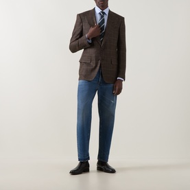 Model wearing Tom Ford black brown wool-silk-linen blend blazer, styled with blue jeans, striped tie and black leather shoes.