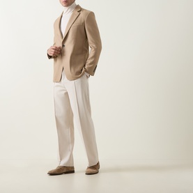 Model wearing Tom Ford camel wool-silk blazer jacket, styled with cream trousers, white turtleneck and tan suede loafers.
