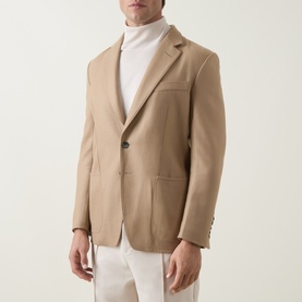 Model wearing Tom Ford camel wool-silk blazer jacket, styled with white roll-neck and white trousers.