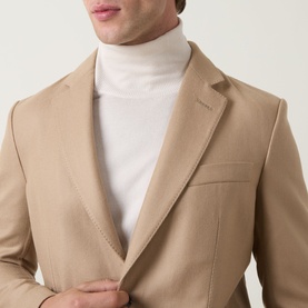 Model wearing Tom Ford camel wool-silk blazer jacket with notched lapels, styled with a white rollneck jumper.