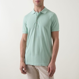 Model wearing Tom Ford Pique Regular Fit Polo Shirt in light green with button-down placket and polo collar, styled with beige trousers.