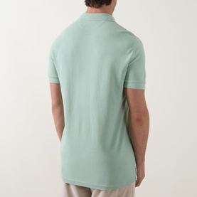 Model wearing Tom Ford Pique Regular Fit Polo Shirt in light green, rear view showing polo collar, short sleeves and side slits.